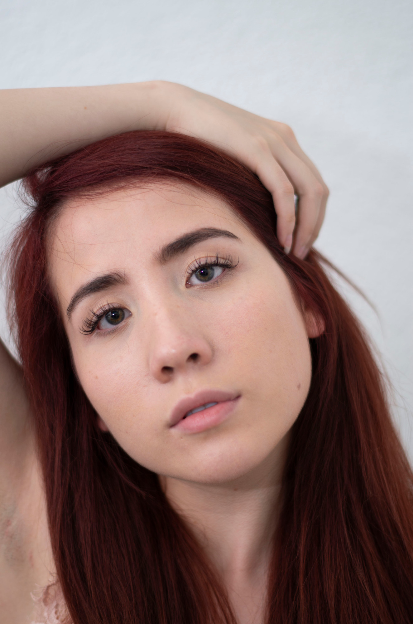 The same high-key beauty portrait before retouching